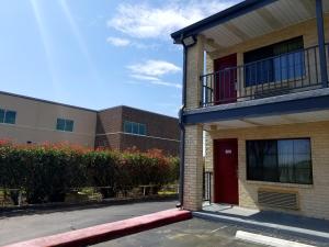 a building with a red door and a balcony at Executive Inn Pasadena in Pasadena