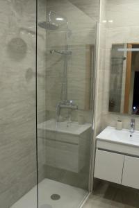 a bathroom with a shower and a sink at Atlântico Flat Douro in Porto +4 photos