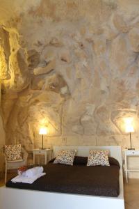 マテーラにあるAgora nei Sassiの大きな石壁のベッドルーム(ベッド付)