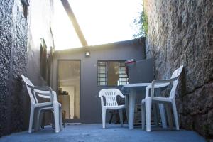 uma mesa e cadeiras sentadas ao lado de uma parede em Eco Box Hostel em Florianópolis