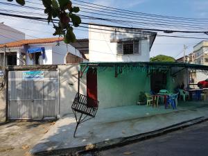 Casa con porche con mesa y sillas en Casa na Ilha, en Río de Janeiro