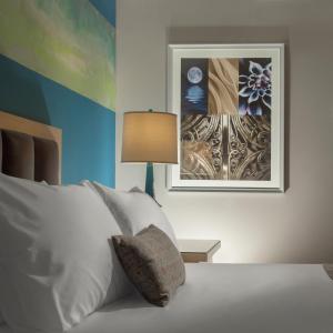 a bedroom with a bed with a lamp and a painting at Downtown Grand Hotel & Casino in Las Vegas