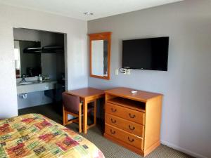 a bedroom with a desk and a bed and a television at Executive Inn Pasadena in Pasadena