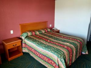 a bedroom with a bed with a colorful comforter at Executive Inn Pasadena in Pasadena