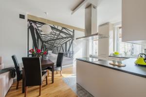 uma cozinha e sala de jantar com mesa e cadeiras em Chmielna Warsaw Cental Station P&O Serviced Apartments em Varsóvia