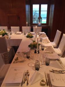une table avec des nappes blanches et des bougies dans l'établissement Hotel Restaurant Schlössli Sax, à Sax