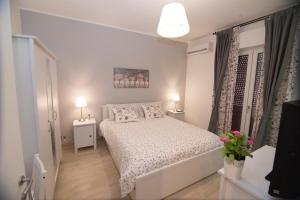 a small bedroom with a white bed and two lamps at B&B Borgo Antico in Poggiorsini