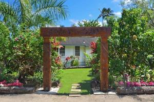 a large wooden arch in front of a house at Fern Grotto Inn in Kapaa