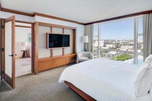 een slaapkamer met een groot bed en een groot raam bij Carillon Miami Wellness Resort in Miami Beach