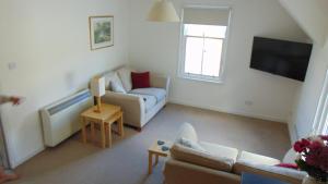 a living room with a couch and a tv at Montclaire in Ballater