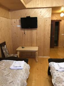 a room with two beds and a tv on the wall at Ресторан-Готель Міжгірʼя in Usteriki