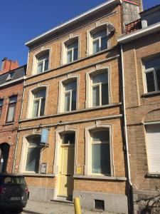 a brick building with a yellow door on a street at B&B Sabbajon in Ypres