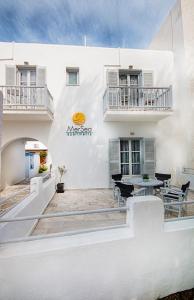 un edificio bianco con patio arredato con tavolo e sedie di MerSea apartments a Paroikia