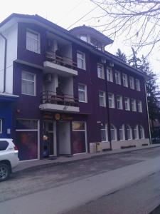 ein großes lila Gebäude an der Straßenseite in der Unterkunft Family Hotel Helios in Sewliewo