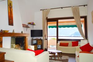 a living room with white furniture and a fireplace at Cadenabbia Fantastico in Griante Cadenabbia