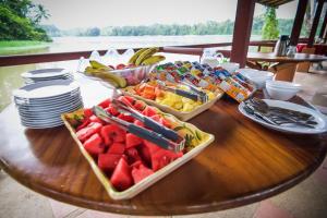 a wooden table with a tray of fruits and vegetables at Lirio Lodge in Barra de Pacuare