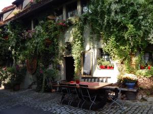 einen Tisch und Stühle vor einem Gebäude mit Blumen in der Unterkunft Altfraenkische Weinstube in Rothenburg ob der Tauber