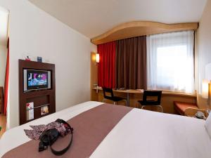 ブリュッセルにあるイビス ホテル ブリュッセル エクスポ アトミウムの大きなベッドとテーブルが備わるホテルルームです。