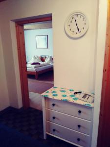 ein Schlafzimmer mit einer Kommode und einer Uhr an der Wand in der Unterkunft Ferienwohnung Hobelleitner in Sankt Blasen