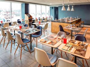a restaurant with tables and chairs and a bar at ibis London Elstree Borehamwood in Borehamwood +37 photos