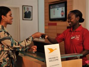 a woman is handing a woman a phone at Ibis Dakar in Dakar