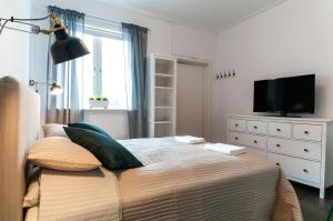 a bedroom with a bed with a television and a dresser at Cozy Studio in Uppsala