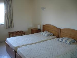 アルヴォルにあるVila Marachique lt 6 108のベッドルーム1室(ベッド2台、窓付)