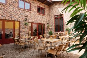 a patio with tables and chairs and a brick building at Hotel Verhoeven in Uden