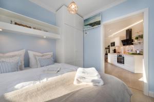 a white bedroom with a large bed and a kitchen at Villa Strandblick 8 in Zingst