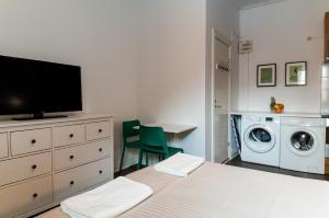 1 dormitorio con 1 cama y lavadora en Cozy Studio, en Uppsala