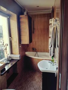 a bathroom with a bath tub and a sink at Apartament Szczawno-Zdrój in Szczawno-Zdrój