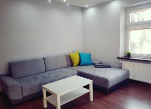 a living room with a couch and a table at Apartament Szczawno-Zdrój in Szczawno-Zdrój