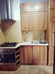 uma cozinha com armários de madeira, um lavatório e um fogão em Apartament Szczawno-Zdrój em Szczawno-Zdrój