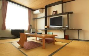 a living room with a table and a tv at Moritsubetsu in Tsubetsu