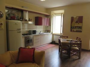 a kitchen with a table and a kitchen with a refrigerator at La Casa nel Borgo in Torre Orsina