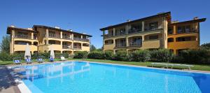 a swimming pool in front of two apartment buildings at Sirmione, Borgo Rosa, your holiday flat in Sirmione