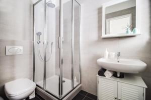 ein Badezimmer mit Dusche, Toilette und Waschbecken in der Unterkunft Trendy Local Apartment in Prag