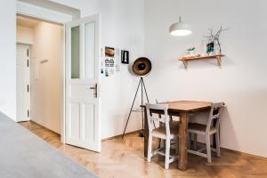 ein Esszimmer mit Tisch und Stühlen und einer weißen Wand in der Unterkunft Trendy Local Apartment in Prag + 36 Fotos
