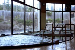 a swimming pool with a chair in a room with windows at Moritsubetsu in Tsubetsu