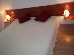 a bedroom with a large white bed with two lamps at Vila Ivančica 2 in Vodice