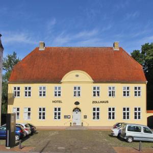 シュレースヴィヒにあるHotel Zollhausの赤い屋根の大きな黄色の建物