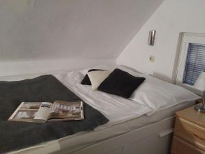 a bed with a book and a magazine on it at Ferienhaus Annelore in Middelhagen