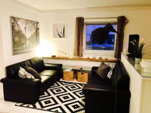 a living room with a black couch and a window at Exkl. Studio nähe Messe in Nürnberg