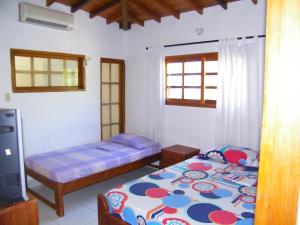1 dormitorio con 2 camas y TV. en Hotel Villa del Mar Coveñas en Coveñas