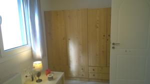 a bathroom with a wooden wall with a window at Dimitra's House in Koskinou +24 photos