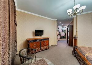 a living room filled with furniture and a tv at Venecia Hotel & SPA in Zaporozhye