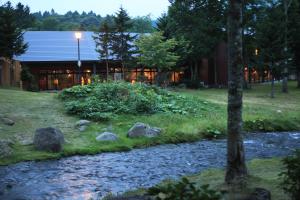 a house with a stream in front of a building at Moritsubetsu in Tsubetsu