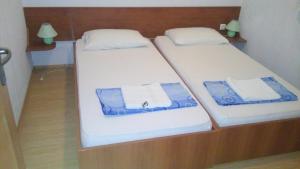 two twin beds in a small room with towels at Vila Ivančica 2 in Vodice