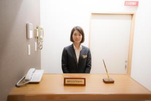 a woman standing in front of a reception desk at City Kaigetsu in Sumoto