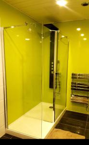 a glass shower in a bathroom with a green wall at My Glasgow House Bishopbriggs in Bishopbriggs